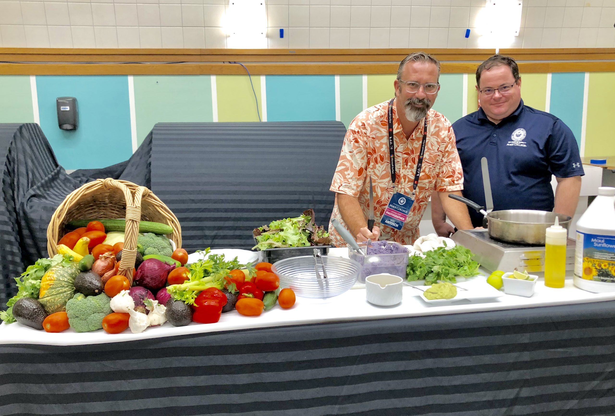Two faculty pose with vegetables