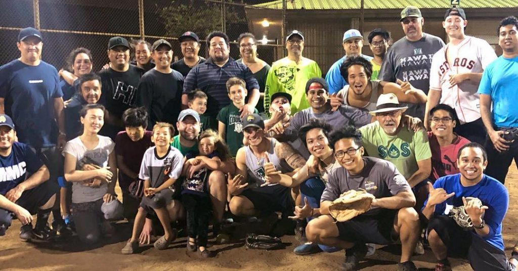 Staff vs students softball game pose for a photo.