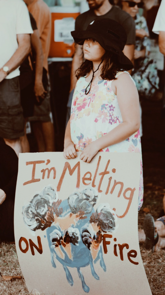 Photo of a young girl with a sign advocating for climate change.