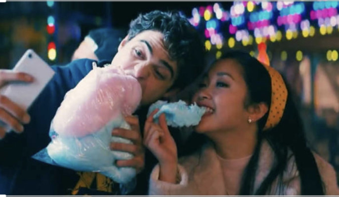 Lara Jean and Peter smile for a pic while eating carnival cotton candy