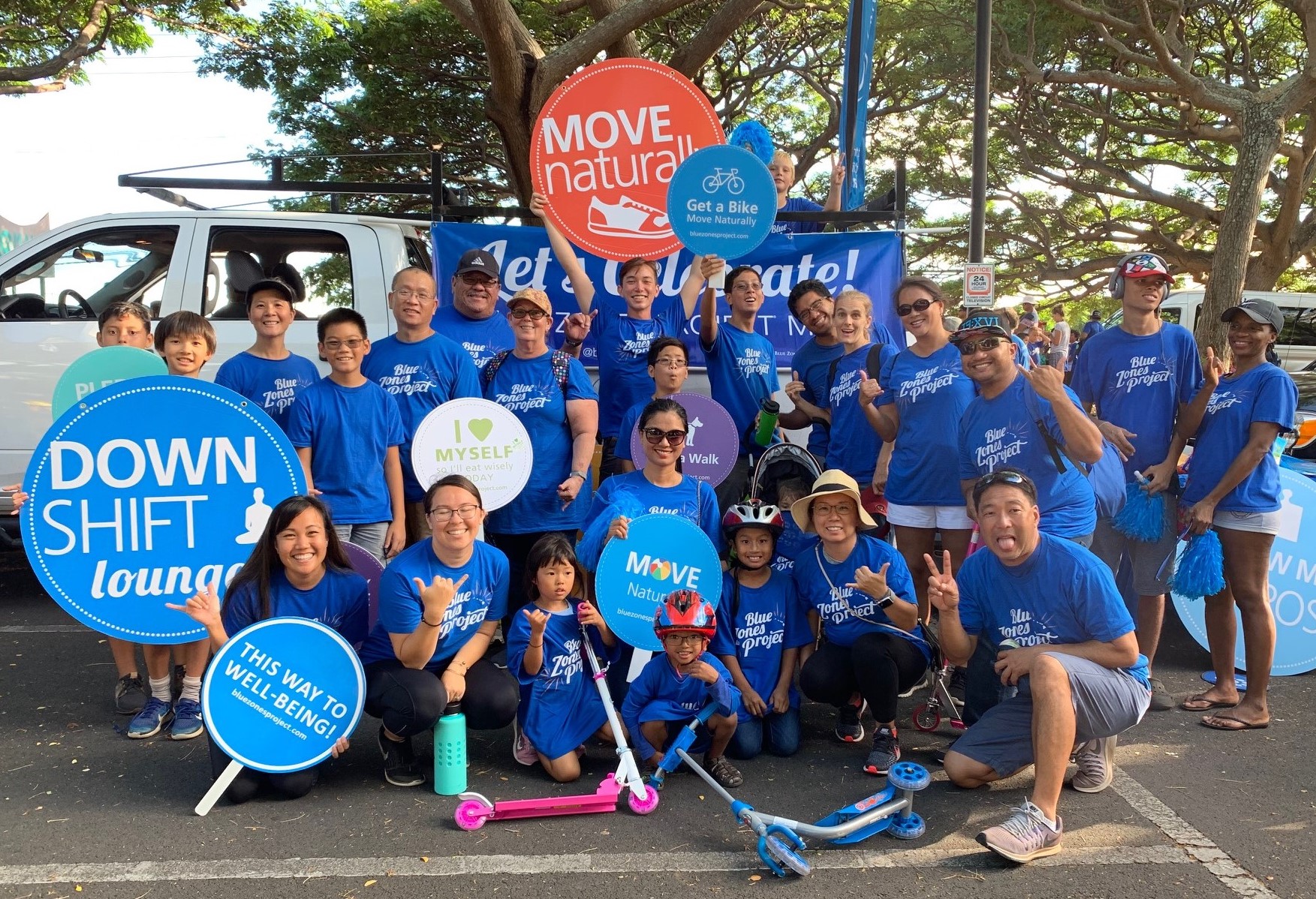 Blue Zones supporters for the Maui Fair Parade pose with posters promoting healthy lifestyles on October 3, 2019